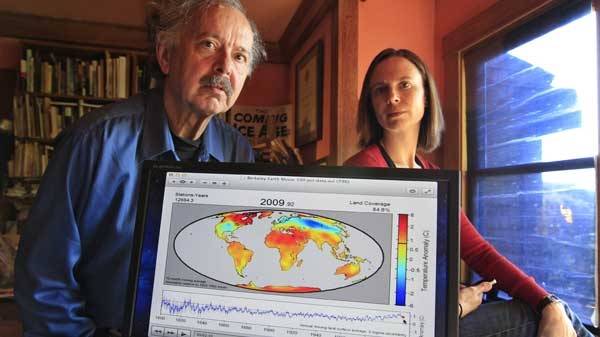 In this Friday, Oct. 28, 2011 photo, Richard Muller, left, and his daughter, Elizabeth Muller, right, pose with a map from their study on climate at their home in Berkeley, Calif. 
