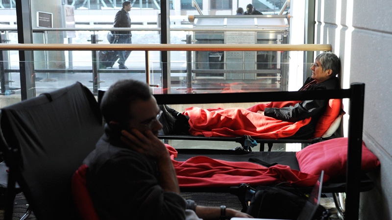 Stranded passengers rest on cots inside at Bradley International Airport, a day after a snowstorm in Windsor Locks, Conn., Sunday, Oct. 30, 2011. (AP / Jessica Hill)