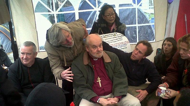 The Right Reverend Richard Chartres, Bishop of London, center, and Dean of St Paul's Cathedral, The Right Reverend Graham Knowles, left, meet a select group from the Occupy London movement in 'the tea tent' at St Paul's before addressing protesters on the steps of the cathedral Sunday Oct. 30, 2011. (AP / Arj Singh / PA Wire)