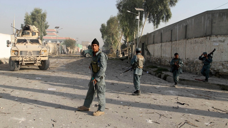 An Afghan police officer stands guard at a checkpoint next to the site of a suicide bombing in Kandahar, Afghanistan, Monday, Oct. 31, 2011. (AP / Allauddin Khan)