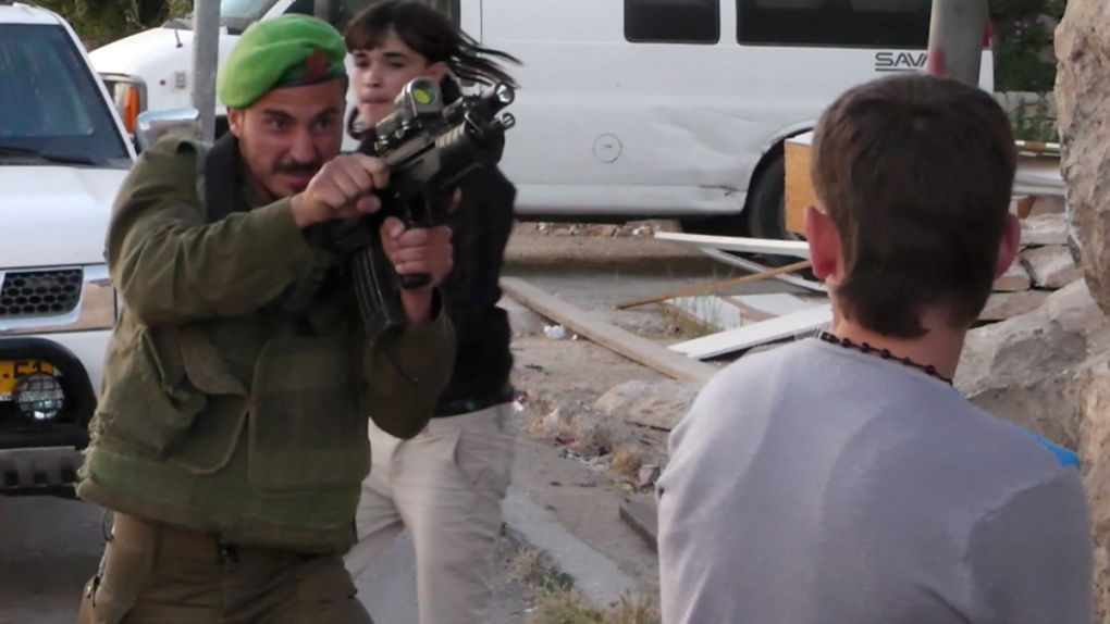 Israeli soldier confronts a Palestinian teen