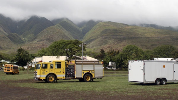 Emergency vehicles from are positioned near Kilohana Elementary School on Molokai, in Hawaii, Thursday, Nov. 10, 2011, after a helicopter taking four tourists on an excursion over the island crashed into a mountainside near the school killing all of the tourists and the pilot, according to authorities. (AP Photo/Joey Salamon)