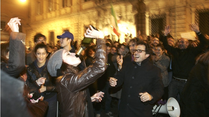 A girl drinks from a bottle in front of Premier Silvio Berlusconi's residence as she celebrates with others after Berlusconi resigned in Rome, Saturday, Nov. 12, 2011. (AP / Riccardo De Luca)