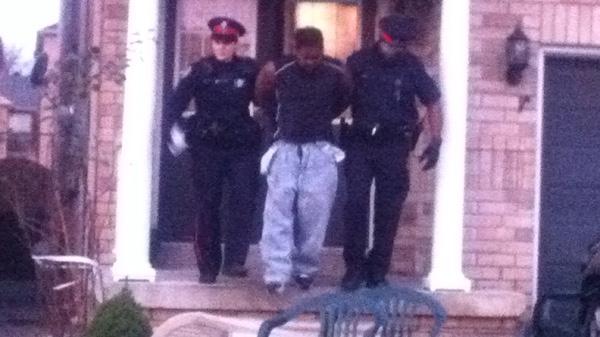 A man is seen being taken into custody by police following an east-end drug raid, Wednesday, Nov. 16, 2011.
