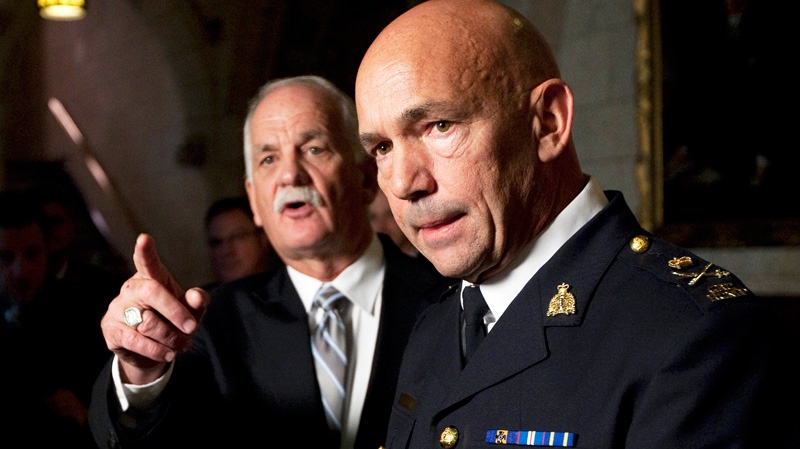 Minister of Public Safety Vic Toews gestures to a reporter as newly appointed RCMP Commissioner Bob Paulson takes questions in the foyer of the House of Commons in Ottawa, Wednesday, Nov. 16, 2011. (Adrian Wyld / THE CANADIAN PRESS)