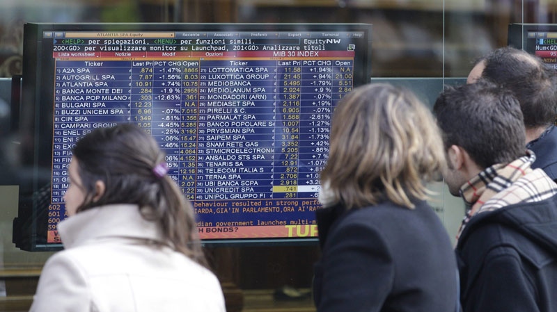 People look at stock market indices on a monitor outside a bank in Milan, Italy, on Nov. 16, 2011