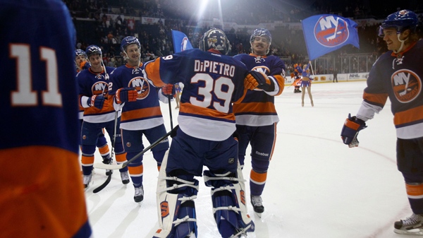 New York Islanders goalie Rick DiPietro celebrates with teammates after defeating the Montreal Canadiens 4-3.  Nov. 17, 2011. (AP Photo/Kathy Willens)