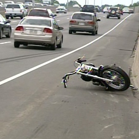 A motorcycle sits on the side of the Queensway in Ottawa, after it collided with a vehicle and shut down a portion of Highway 417, Monday, Aug. 11. 2008.