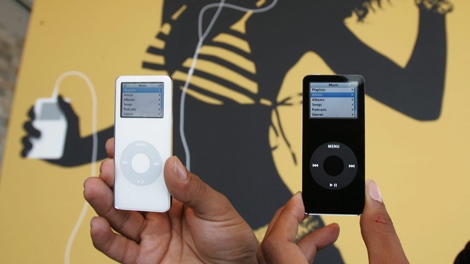 A black and white model of Apple Computers Inc. new iPod Nano on display in front of a giant Apple poster during their announcement in San Francisco, Wednesday, Sept. 7, 2005. (AP Photo/Paul Sakuma)