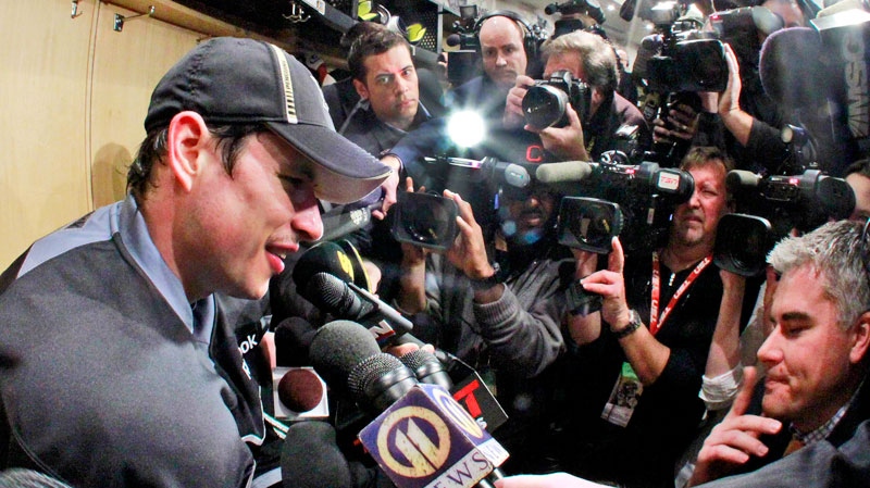 Pittsburgh Penguins' Sidney Crosby, left, is surrounded by media at his locker after a morning skate in preparation for his return to NHL hockey action against the New York Islanders in Pittsburgh,  Monday, Nov. 21, 2011. (AP / Gene J. Puskar)
