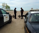 OPP officers stand on the beach in Port Stanley, as the search for a missing person continues on Tuesday, May 27, 2014. (Chuck Dickson/ CTV London)