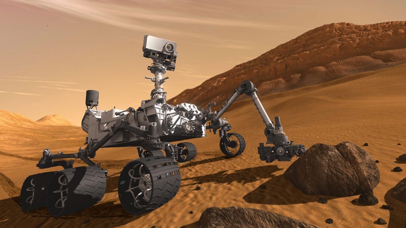 In this 2011 artist's rendering provided by NASA/JPL-Caltech, the Mars Science Laboratory Curiosity rover examines a rock on Mars with a set of tools at the end of its arm, which extends about 2 meters (7 feet). The mobile robot is designed to investigate Mars' past or present ability to sustain microbial life. 