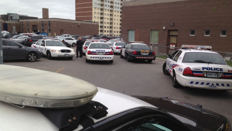 Police vehicles fill a parking lot after a series of guns and drugs raids across Toronto on Wednesday, May 28, 2014. (Aaron Adetuyi / CP24)
