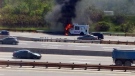 An ice cream truck burns on the side of Highway 401 near Markham Road in Scarborough on Friday, May 30, 2014. 