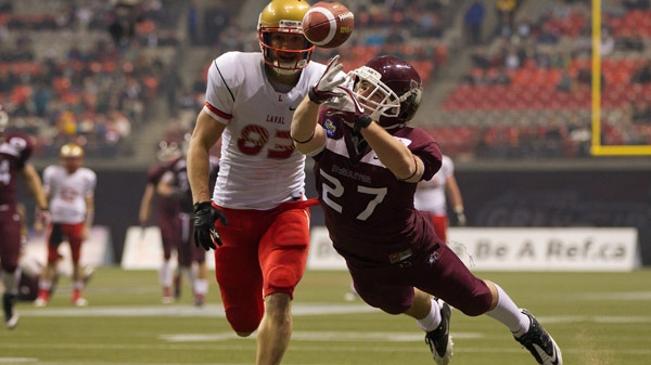 McMaster University Marauders' Scott Martin, right, bobbles the ball as Laval University Rouge et Or's Julian Feoli Gudino defends during the second half of play at the Vanier Cup Canadian university football championship in Vancouver, B.C., on Friday November 25, 2011. Marauders won 41-38 in overtime. THE CANADIAN PRESS/Darryl Dyck