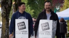 Ryan Tanabe, left, a teacher, and his father Rod Tanabe, a counsellor teacher at Killarney Secondary School, walk the picket line outside the school in Vancouver, B.C., on Monday May 26, 2014. (Darryl Dyck / THE CANADIAN PRESS)