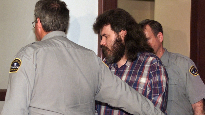 Convicted serial killer Michael Wayne McGray is escorted into provincial court in Halifax on Monday, May 28, 2001. (Andrew Vaughan / THE CANADIAN PRESS)