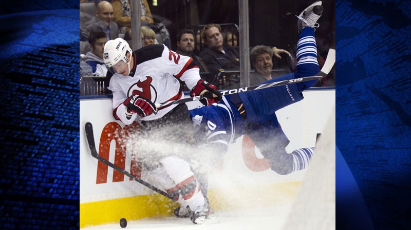 New Jersey Devils centre Ryan Carter (left) takes Toronto Maple Leafs David Steckel (right) head first into the boards as they chase down the puck during second period NHL action in Toronto on Tuesday December 6, 2011. THE CANADIAN PRESS/Frank Gunn