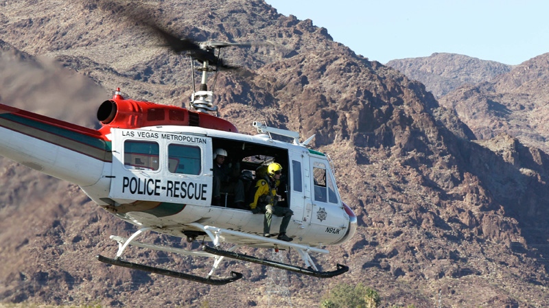 A Las Vegas Metropolitan Police rescue helicopter lift off carrying a scout team to the site of a tour helicopter crash to search for access to begin the recovery process in Las Vegas, Thursday, Dec. 8, 2011. (AP / Julie Jacobson)