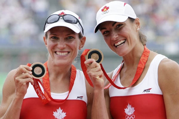Canada's Melanie Kok, left, and Tracy Cameron celebrate with medals after taking the bronze medal in the Lightweight women's sculls final at the Beijing 2008 Olympics in Beijing, Sunday, Aug. 17, 2008. (AP Photo/Gregory Bull)