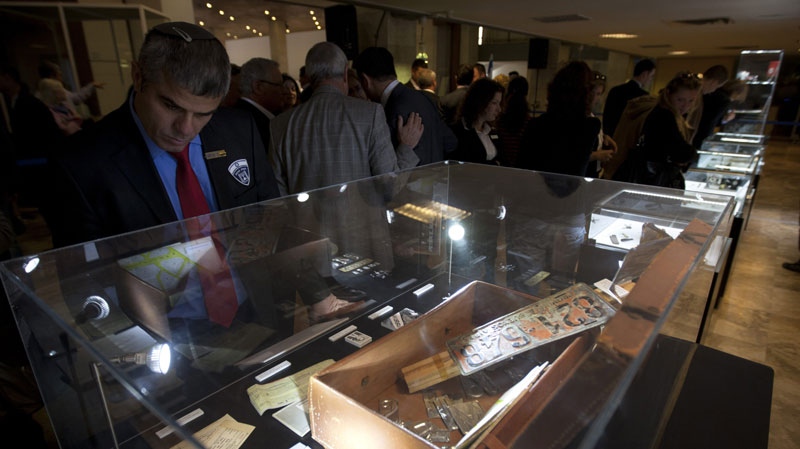 Visitors view a fake licence plate and other objects used in the operation to capture Nazi SS officer Adolf Eichmann, during an opening of an exhibition about Eichmann's capture, in the Knesset, Israel's parliament, in Jerusalem, Monday, Dec. 12, 2011. 