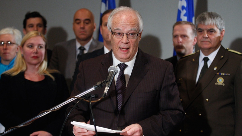 Quebec Public Security Minister Roberet Dutil, flanked by police representatives and gun control supporters, announces the government's decision to go to court to stop the destruction of the gun registry Tuesday, Dec. 13, 2011 in Quebec City. (Jacques Boissinot / THE CANADIAN PRESS)  