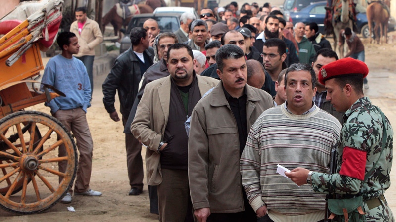 Egyptians, some are tourist camel riders, line up outside a polling station in Giza, Egypt, Wednesday, Dec. 14, 2011. (AP / Amr Nabil)