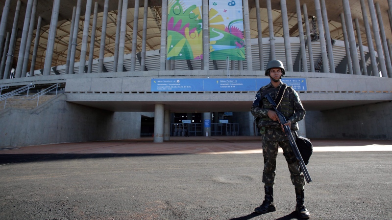 A Brazilian soldier stands guard in front of the National Stadium in preparation for the FIFA soccer World Cup in Brasilia, Brazil, on June 9, 2014. (AP Photo/Eraldo Peres)