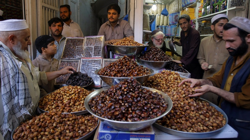 People buy dates, most favorite food for Islamic holy month of Ramadan, at a shop in Peshawar, Pakistan, Saturday, July 28, 2014. (AP / Mohammad Sajjad)