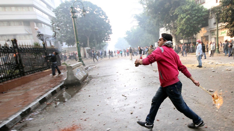 An Egyptian protester throws a fire bomb at military police inside Parliament building during clashes near Cairo's downtown Tahrir Square, Egypt Friday, Dec. 16, 2011.