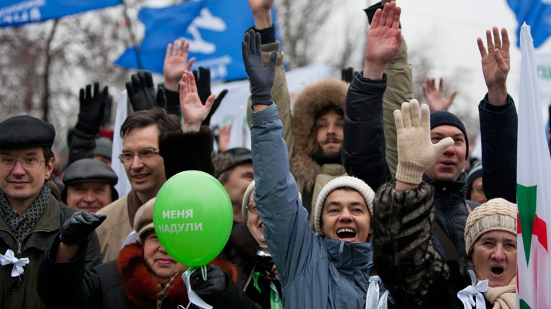 With Yabloko party flags in the background, and a balloon bearing the words 'They cheated me', Russian protesters gesture during a rally to protest against alleged vote rigging at Bolotnaya Square, on an island in the Moscow River adjacent to the Kremlin in Moscow, Russia
