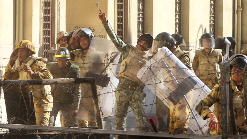 An Egyptian military solider throws a rock toward protesters near Tahrir Square in Cairo, Egypt, Sunday, Dec. 18, 2011. (AP / Ahmed Ali)