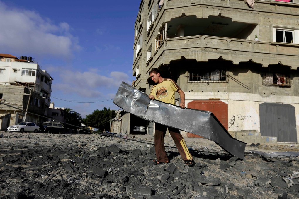 A Palestinian man carries rubble near a Hamas trai