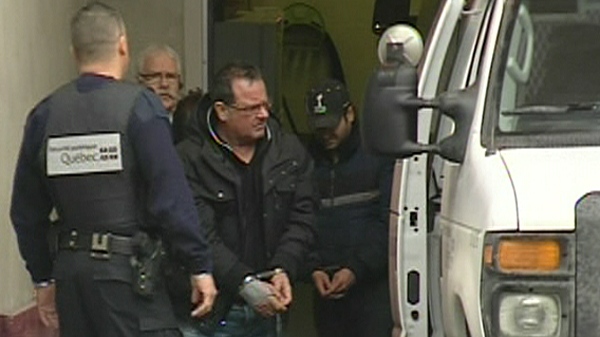 Raynald Desjardins, in handcuffs, exits a police van in Joliette (Dec. 21, 2011)