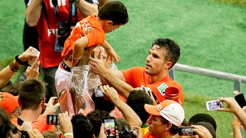 Netherlands' Robin van Persie holds a boy as he ce