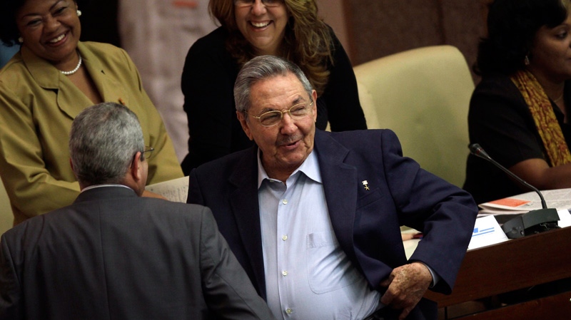 Cuba's President Raul Castro, center, smiles as he talks to parliament members during a parliamentary meeting in Havana, Cuba, Friday Dec. 23, 2011.  (AP Photo/Ismael Francisco, Prensa Latina)