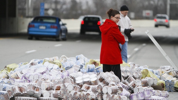 A member from the Health Department checks the condition of ice cream that spilled on Interstate 69 in Fort Wayne, Indiana, on Friday, Dec. 23, 2011. (The Journal-Gazette / Michelle Davies)
