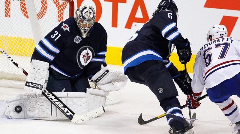Winnipeg Jets goaltender Ondrej Pavelec (31) gets his pad on Montreal Canadiens forward Max Pacioretty's (67) shot during third period NHL action in Winnipeg on Thursday, December 22, 2011.