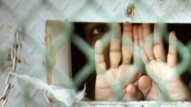 In this photo reviewed by the U.S. Military, a detainee peers out from his cell inside the Camp Delta detention facility at the Guantanamo Bay U.S. Naval Base in Cuba on Dec. 4, 2006. (AP / Brennan Linsley)