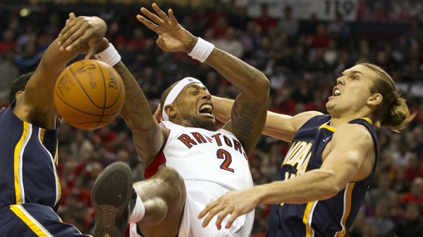 Toronto Raptors forward James Johnson tumbles as he battles for a rebound with Indiana Pacers forwards Danny Granger (left) and Lou Amundson (right) during first half NBA action in Toronto on Wednesday, Dec. 28, 2011.