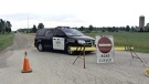 An OPP vehicle blocks Arkona Road near a home where the body of a woman was found in Lambton County, Ont. on Monday, July 14, 2014. (Steve Ward / CTV London)