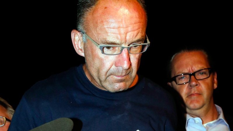 Douglas Garland is escorted into a Calgary police station, late Monday, July 14, 2014. (Jeff McIntosh / THE CANADIAN PRESS)  