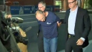 Douglas Garland is escorted by CPS members to the arrest processing unit