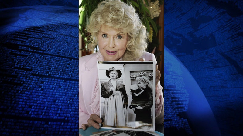 In this Jan. 8, 2009 photo, Donna Douglas, who starred in the television series "The Beverly Hillbillies" poses with a photo from the show in Baton Rouge, La.