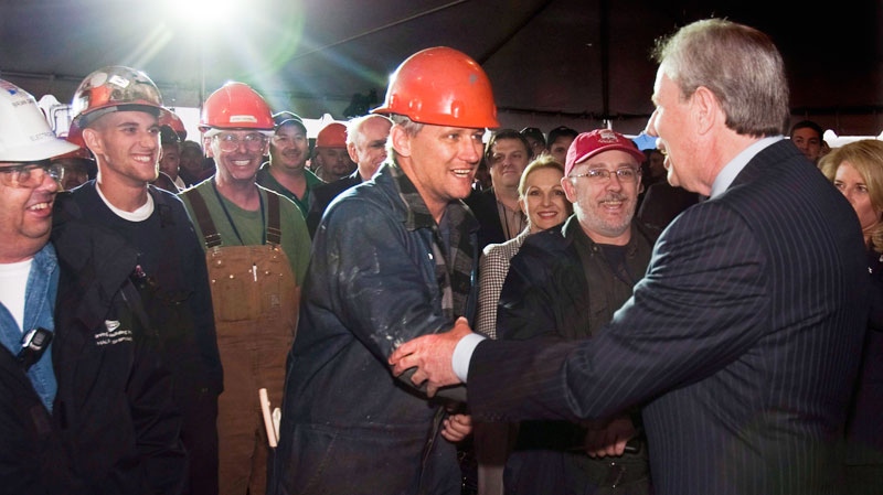 Jim Irving, right, CEO of Irving Shipbuilding, greets workers at the announcement that Halifax Shipyard is getting the $25 billion contract to build 21 Canadian combat ships, in Halifax on Oct. 19, 2011. (Andrew Vaughan / THE CANADIAN PRESS)