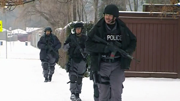 Police task force units probe the scene of a deadly shooting in Scarborough, Friday, Dec. 30, 2011.