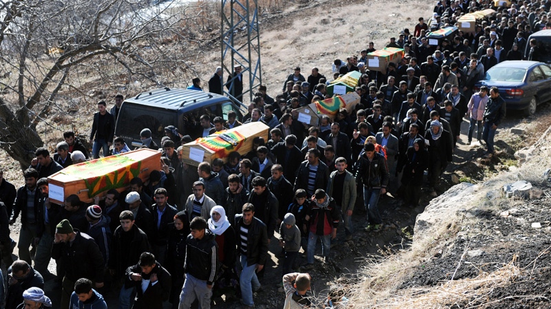 People carry the coffins of victims as thousands of mourners gathered in Gulyazi village at the border with Iraq, southeast Turkey, Friday, Dec. 30, 2011 for the funerals of 35 Kurdish civilians who were killed in a botched raid by Turkish military jets that mistook the group for Kurdish rebels based in Iraq. Turkish television footage showed people, many weeping and lamenting the dead, as they gathered after the air strikes Wednesday that killed a group of smugglers along the border, one of the deadliest episodes in the conflict between the Turkish state and Kurdish rebels who took up arms in 1984.