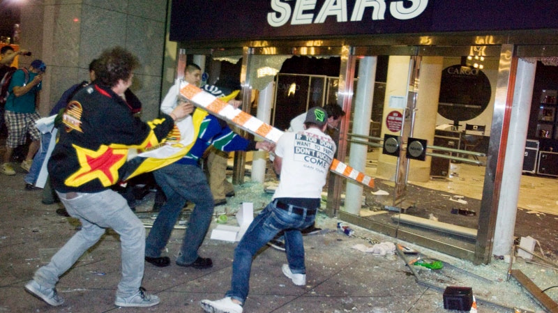 Rioters break the front doors of a Sears department store on Granville Street during the riot following game 7 of the NHL Stanley Cup final in downtown Vancouver on June 15, 2011. (Geoff Howe / THE CANADIAN PRESS)