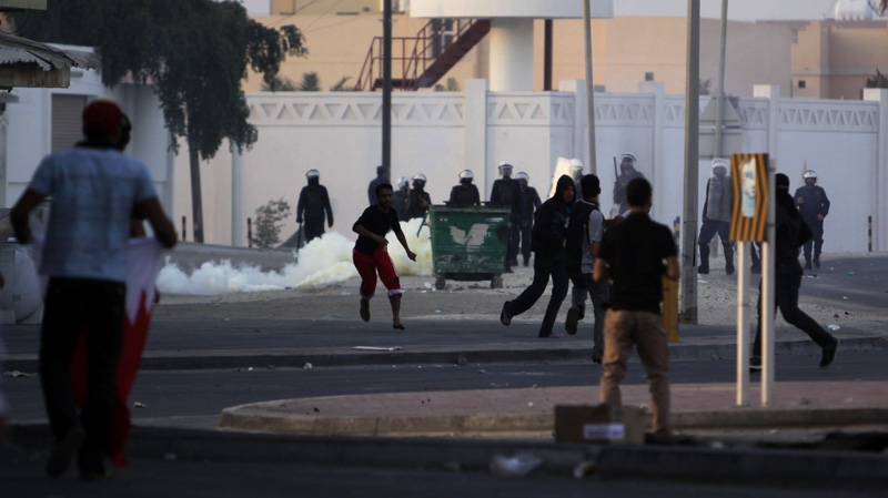 Bahraini anti-government protesters clash with riot police firing tear gas in front of a police station Saturday, Dec. 31, 2011, in the western Shiite Muslim village of Karzakan, Bahrain.