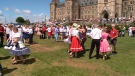 Square dancers spin their partners on Parliament Hill, Wednesday, July 17, 2014